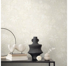 Scene met beige behang met plantenmotief, tafel met decoraties zoals sculpturen en vazen