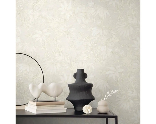 Scene met beige behang met plantenmotief, tafel met decoraties zoals sculpturen en vazen