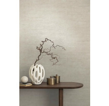 Decoratieve vaas met tak op een houten tafel voor een gestructureerde wand