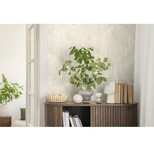 Decoratieve ruimte met patroonbehang, houten commode en bloemstuk.