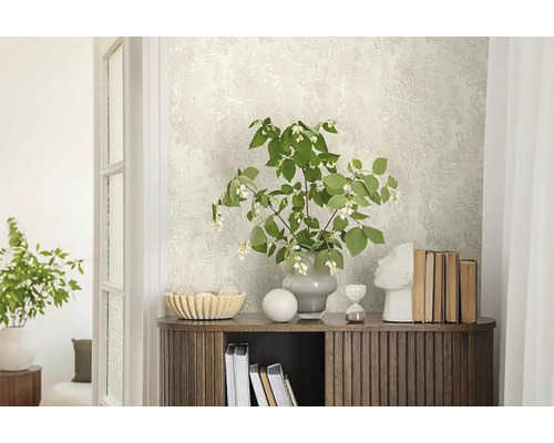 Decoratieve ruimte met patroonbehang, houten commode en bloemstuk.