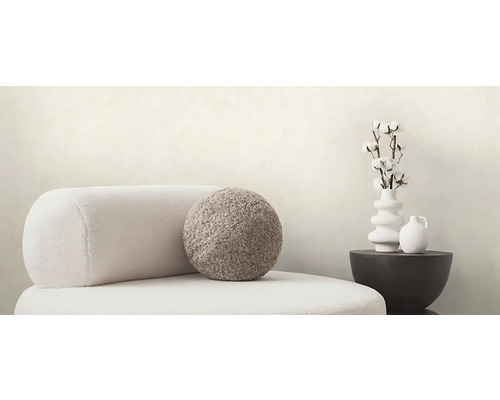 Scene met fauteuil, kussen en decoratie op een bijzettafel