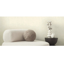 Decoratieve scène met fauteuil, rond kussen, vaas met katoentakken en tafel