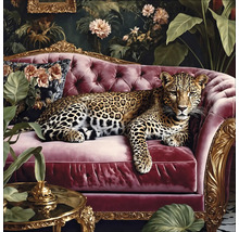 Een luipaard ligt op een rode bank voor een bloemdecoratie.