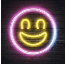 Neon decoratie met smiley motief aan een bakstenen muur
