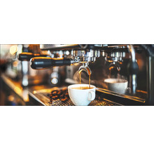 Koffie stroomt van een espressomachine in een kopje.