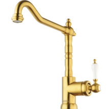 Goudkleurige keukenkraan met porseleinen handgreep