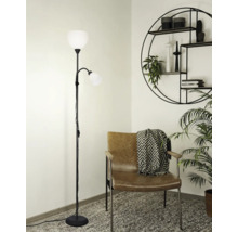 Vloerlamp met twee lampen naast een fauteuil en een wandrek