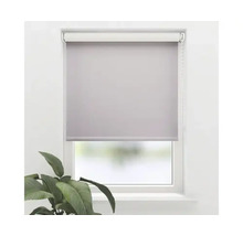 Uitzicht op een raam met een grijs rolgordijn.