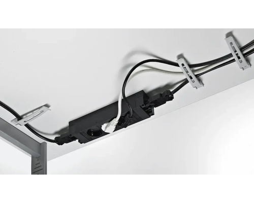 Zwart kabelkanaal met stopcontact voor kabelbeheer onder een bureau.