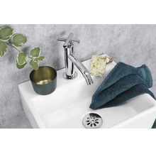 Moderne wastafel met kraan, zeep, handdoek en beker