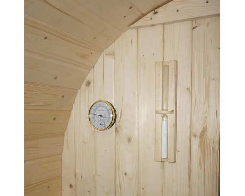 Sauna accessoires aan een houten wand: thermometer en zandloper