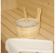 Houten emmer met ijs en een lepel in een sauna, naast een handdoek.