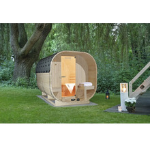 Houten barrelsauna in de tuin met boom en tuinverlichting