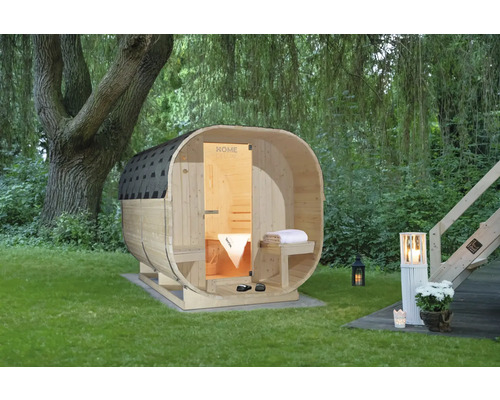 Houten barrelsauna in de tuin met boom en tuinverlichting