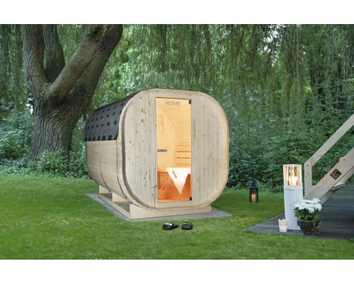 Houten barrelsauna in de tuin met verlichting
