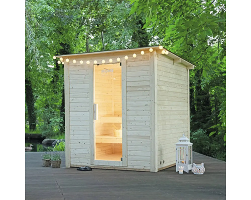 Houten sauna buiten met lichtsnoer en open deur