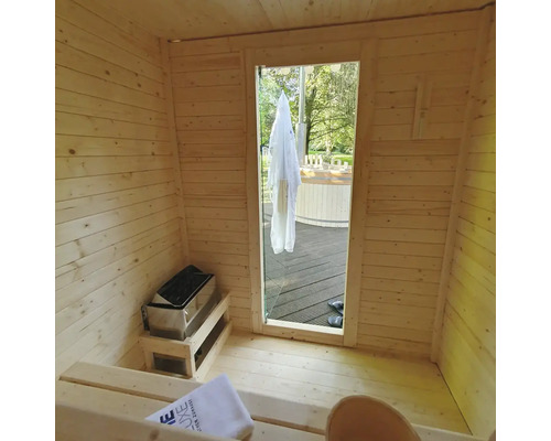 Interieur van een houten sauna met saunakachel en uitzicht naar buiten