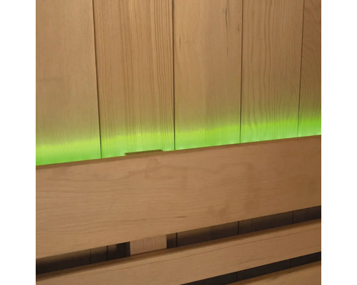 Close-up van een saunabank voor een houten lambrisering met groene verlichting