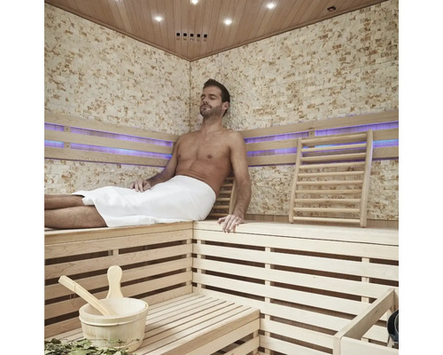 Sauna met houten panelen en ontspannende man