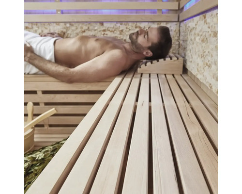 Man ontspant in een sauna met houten banken en accessoires.