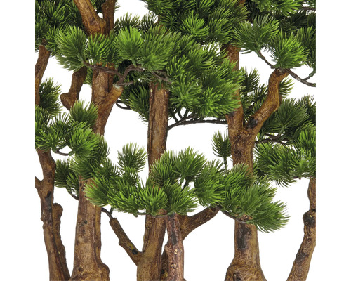 Close-up van kunstmatige dennentakken met bruine stammen en groene naalden.