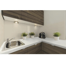 Roestvrijstalen hoekgootsteen met kraan, ingebouwd in een keukenblok met houten fronten