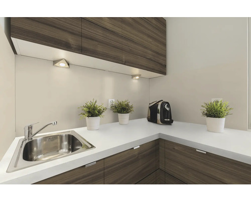 Roestvrijstalen hoekgootsteen met kraan, ingebouwd in een keukenblok met houten fronten