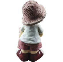 Tuinbeeld van een jongen met een hoed en korte broek van achteren