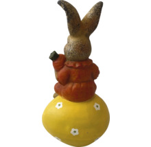 Decoratieve haas op een paasei met een wortel in de hand als tuindecoratie