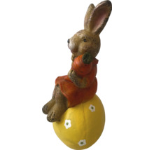 Paashaas op een geel ei als tuindecoratie