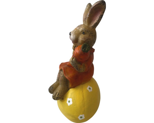 Paashaas op een geel ei als tuindecoratie