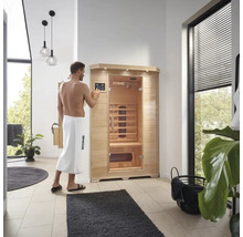 Man bedient een Home Deluxe infraroodsauna in een badkamer