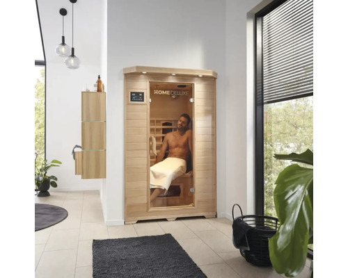 Interieurfoto van een badkamer met een Home Deluxe sauna en een man met een handdoek