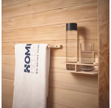 Handdoek aan handdoekhouder, drinkfles en glas op een plank voor een houten wand