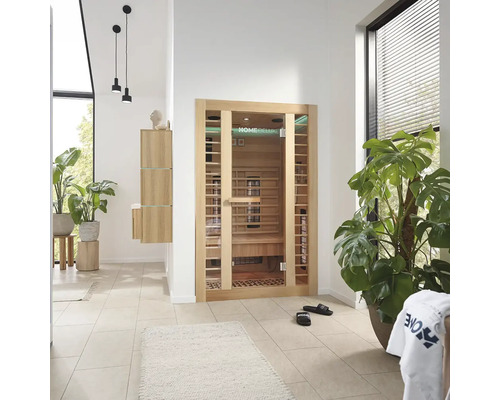 Lichte ruimte met Home Deluxe sauna, planten en badkamermeubels.