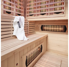 Interieur van een infraroodsauna met houten panelen, zitbank en handdoek