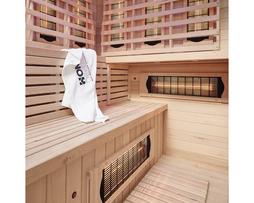 Interieur van een infraroodsauna met houten panelen, zitbank en handdoek