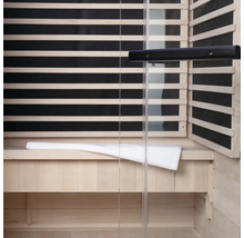 Interieur van een sauna met houten lambrisering, glazen voorkant en een bank met handdoek
