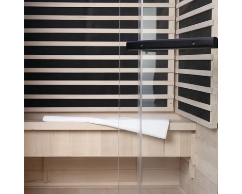 Interieur van een sauna met houten lambrisering, glazen voorkant en een bank met handdoek