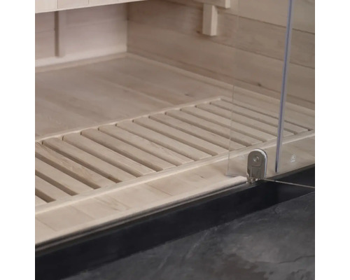 Detailopname van een sauna-interieur met houten vloer en glazen deur