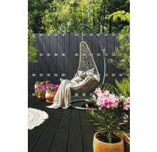 Hangstoel met kussens en deken op een terras met houten vloer en planten