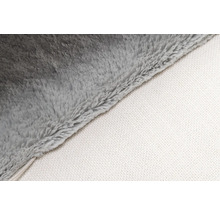 Detailopname van een grijze fleecedeken met witte onderkant.