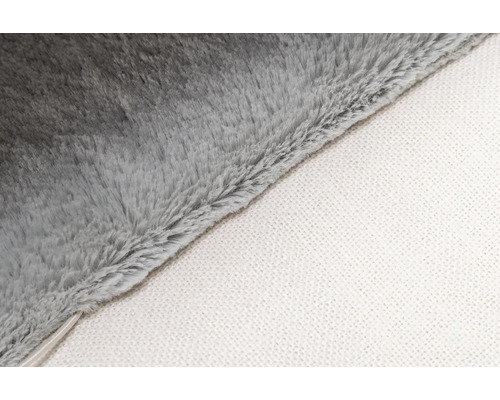 Detailopname van een grijze fleecedeken met witte onderkant.