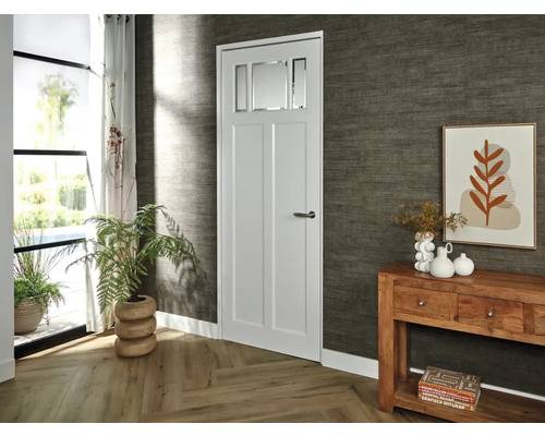 Lichte kamer met binnendeur met glazen inzet, console en kamerplanten voor een vriendelijke sfeer.