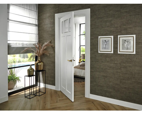 Interieur van een kamer met een gedeeltelijk geopende witte binnendeur, decoratie en twee ingelijste foto's aan de muur