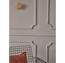 Muur met stucwerk, houten haak en metalen stoel met kussen