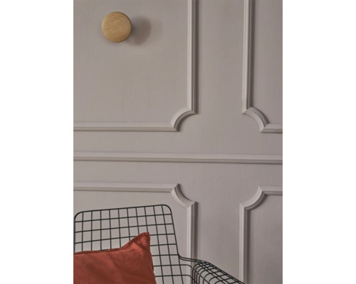 Muur met stucwerk, houten haak en metalen stoel met kussen