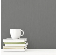 Grijs vliesbehang met textielstructuur naast een kop en boeken