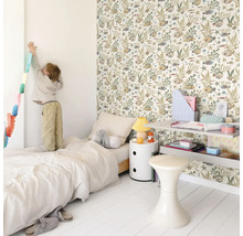 Lichte kinderkamer met bed, nachtkastje, plank, kruk en een muur met behang met dierenmotief.